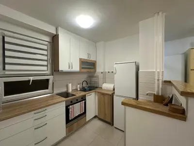 a kitchen with white cabinets and a refrigerator at City Centre Retreat Pionir Apartment in Belgrade