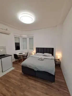 a bedroom with a bed and a table and chairs at White City 6 in Belgrade