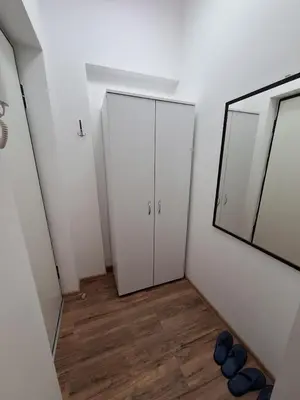 a hallway with two white cabinets and a mirror at White City 6 in Belgrade