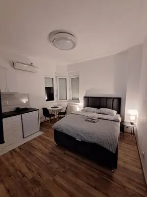 a bedroom with a bed and a table and chairs at White City 6 in Belgrade