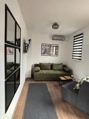 a living room with a green couch and a table at Apartment 5th in Belgrade