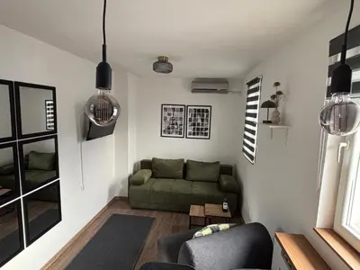 a living room with a green couch and a table at Apartment 5th in Belgrade