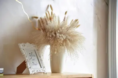 a vase filled with dried flowers next to a window at Casa Novi Dorcol Belgrade in Belgrade