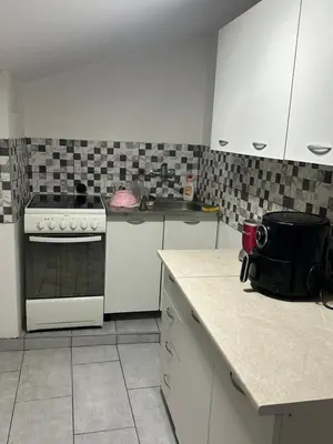 a kitchen with a stove and a counter top at Apartman Riven in Borča