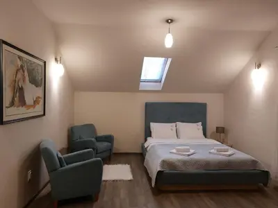 a bedroom with a bed and a pair of chairs at Bellmatini 07 in Tošin Bunar