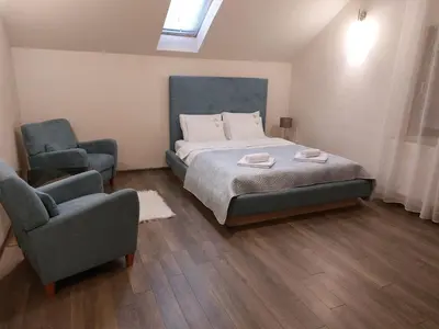 a bedroom with a bed and two chairs in it at Bellmatini 07 in Tošin Bunar