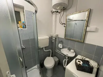 a bathroom with a toilet and a sink and a mirror at Bellmatini 07 in Tošin Bunar