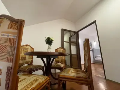 a dining room with a table and chairs and a mirror at Bellmatini 07 in Tošin Bunar