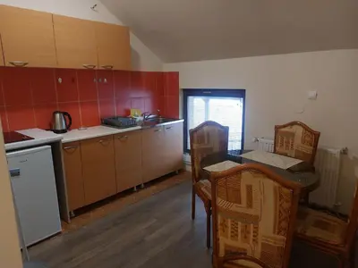 a kitchen with a table and chairs in a room at Bellmatini 07 in Tošin Bunar