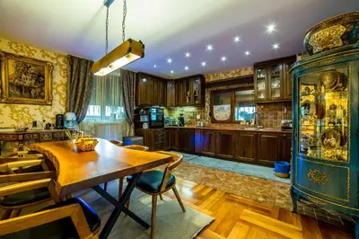 a kitchen with a wooden table and a dining room at Alrawda Resort in Risti°i