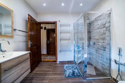 a bathroom with a shower and a sink at Alrawda Resort in Risti°i
