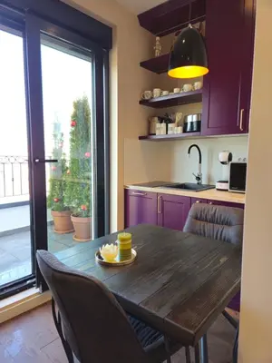 a kitchen with a wooden table and chairs and a window at Sky Terrace Belgrade in Belgrade