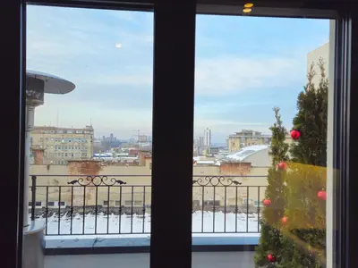 a window with a christmas tree on a balcony at Sky Terrace Belgrade in Belgrade