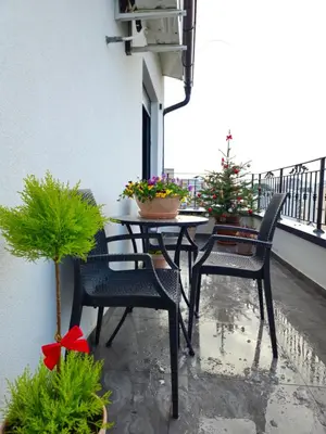 a table and chairs on a balcony with christmas trees at Sky Terrace Belgrade in Belgrade