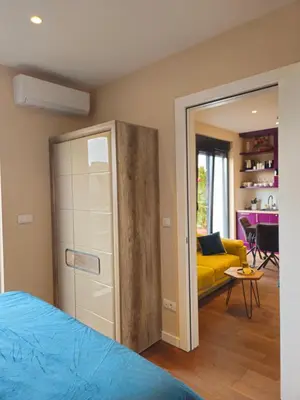a bedroom with a bed and a yellow couch at Sky Terrace Belgrade in Belgrade