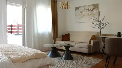 a bedroom with a bed and a couch and a table at Mocha Belgrade Apartment in Belgrade