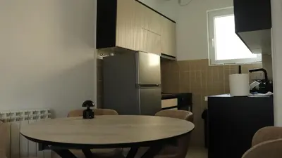 a kitchen with a table and a refrigerator at Mocha Belgrade Apartment in Belgrade