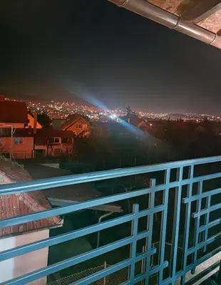 a view of a city at night from a balcony at Buku Hill in Arandjelovac