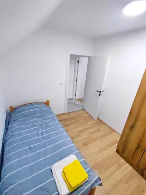 a bedroom with a bed with a blue comforter at Buku Hill in Arandjelovac