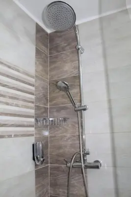 a shower with a shower head in a bathroom at TenMinutesToCenter Apartment in Belgrade