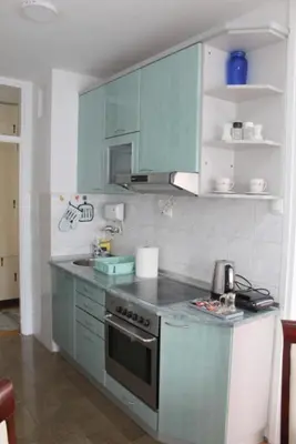 a kitchen with blue cabinets and a stove at TenMinutesToCenter Apartment in Belgrade