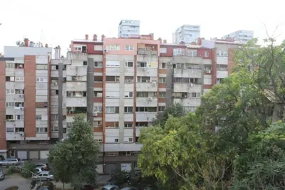 a large apartment building with trees in front of it at TenMinutesToCenter Apartment in Belgrade