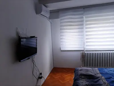a bedroom with a flat screen tv and a bed at TenMinutesToCenter Apartment in Belgrade