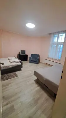 a room with two beds and a chair and a television at Industrial 29N in Belgrade
