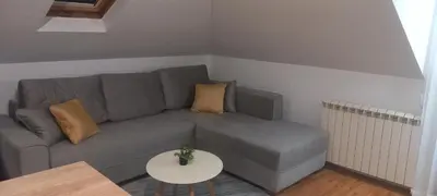 a living room with a gray couch and a table at Naru in Belgrade