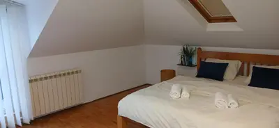 a bedroom with a bed with white sheets and blue pillows at Naru in Belgrade