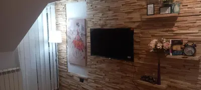a flat screen tv on a brick wall at Naru in Belgrade