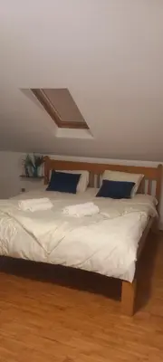 two beds in a room with white sheets and blue pillows at Naru in Belgrade