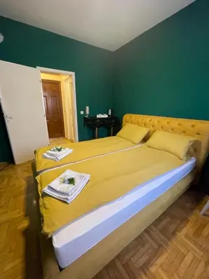 a large bed in a room with a green wall at Apartman Hram in Belgrade