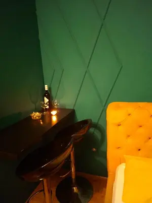 a green room with a table and a bottle of wine at Apartman Hram in Belgrade