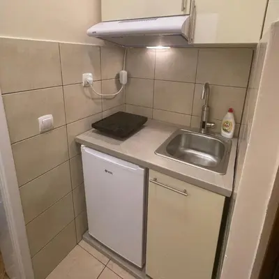 a small kitchen with a sink and a counter top at Apartman Hram in Belgrade