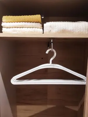 a white hanger on a shelf with towels at Dorian Gray Apartment in Belgrade