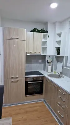 a kitchen with wooden cabinets and a sink at Finans2 in Ruma