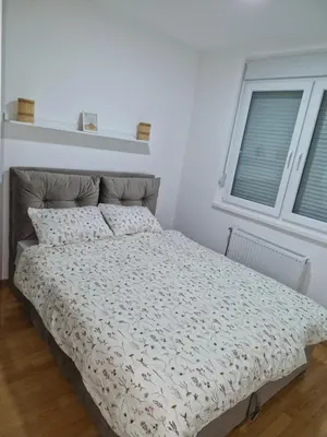 a bed in a white bedroom with a window at Finans2 in Ruma