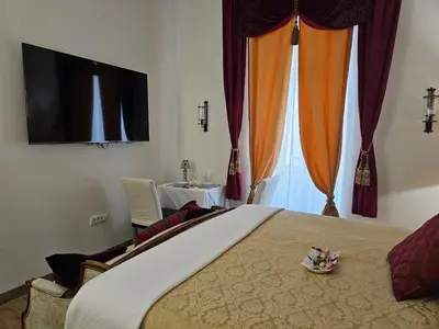 a bedroom with a bed and a television and curtains at Belgrade Luxury Suite 17 in Belgrade