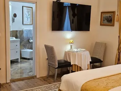 a room with a table and chairs and a bathroom at Belgrade Luxury Suite 19 in Belgrade