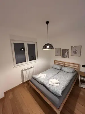 a bedroom with a bed with two towels on it at Krfska Lux by Magenta in Belgrade