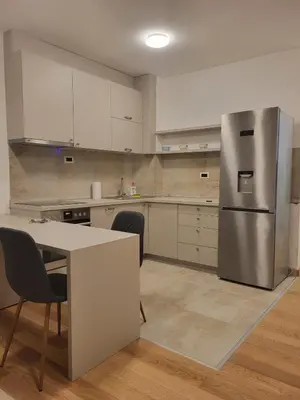 a kitchen with a stainless steel refrigerator and a table at Krfska Lux by Magenta in Belgrade