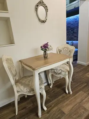 a table with two chairs and a vase with flowers at Studio Suzi in Belgrade