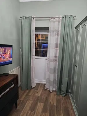 a living room with green curtains and a window at Studio Suzi in Belgrade