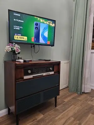a flat screen tv sitting on top of a wooden entertainment center at Studio Suzi in Belgrade