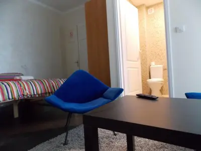 a room with a blue chair and a table at Guest House Miss Depolo in Belgrade