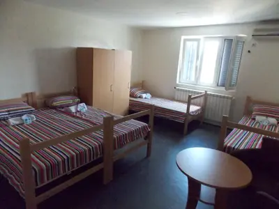 a room with two beds and a table and a chair at Guest House Miss Depolo in Belgrade