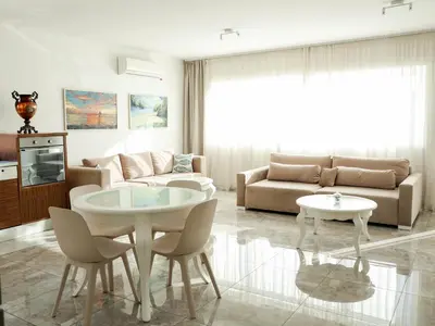 a living room with a couch and a table and chairs at Golden Gate 21 in Ruma