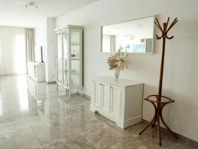 a white room with a vase of flowers on a table at Golden Gate 21 in Ruma