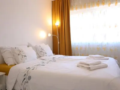 a bedroom with a white bed with towels on it at Golden Gate 21 in Ruma